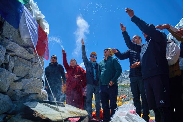 Kami Rita Sherpa, third left, who holds the record for most ascents to Mount Everest, prays with other mountaineers at Everest Base Camp before beginning his ascent to the summit of Mount Everest in Nepal, April 24, 2025. (AP Photo/Pasang Rinzee Sherpa)
