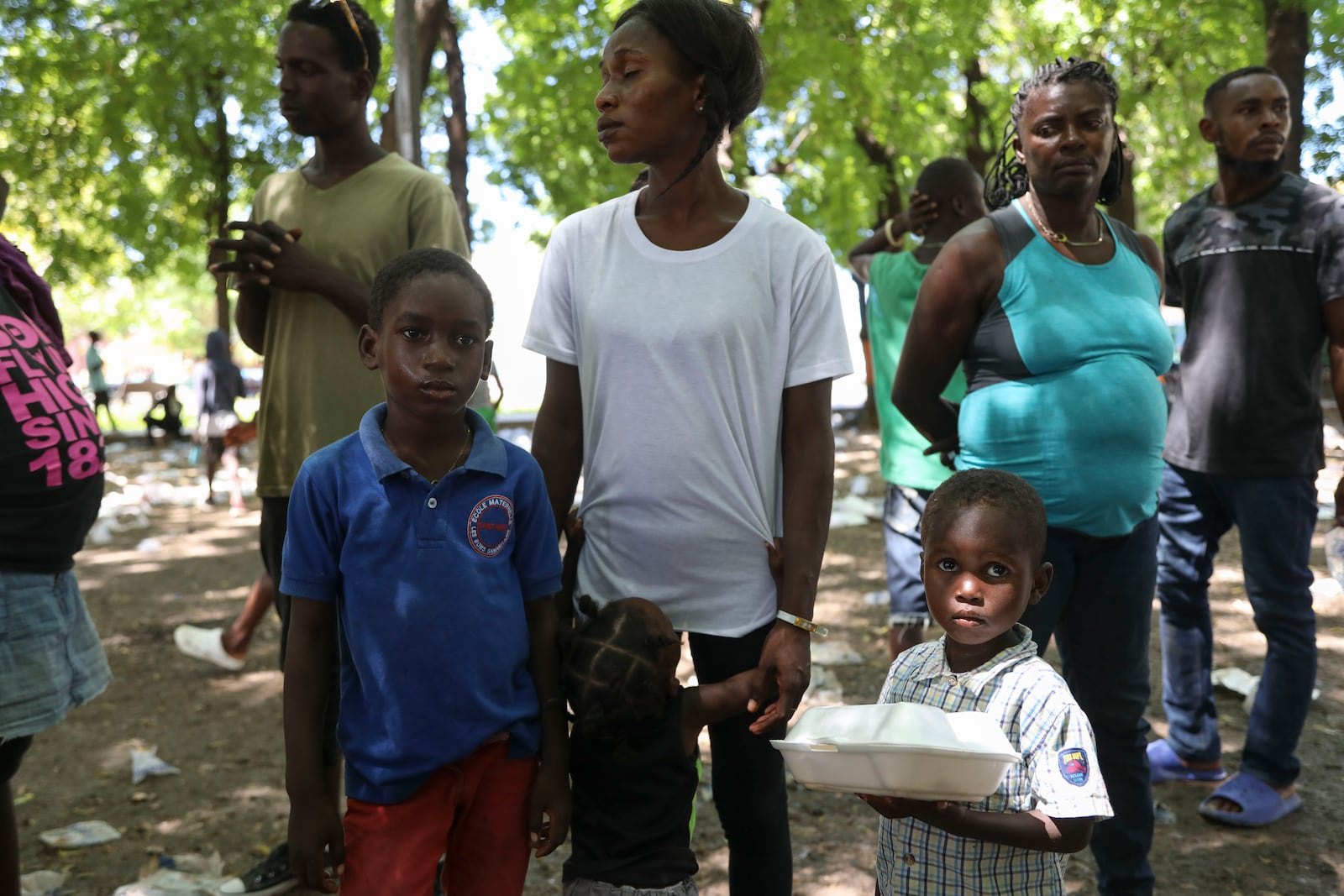 People displaced by armed attacks receive food from a nongovernmental organization in Saint-Marc, Haiti, Sunday, Oct. 6, 2024. (AP Photo/Odelyn Joseph)