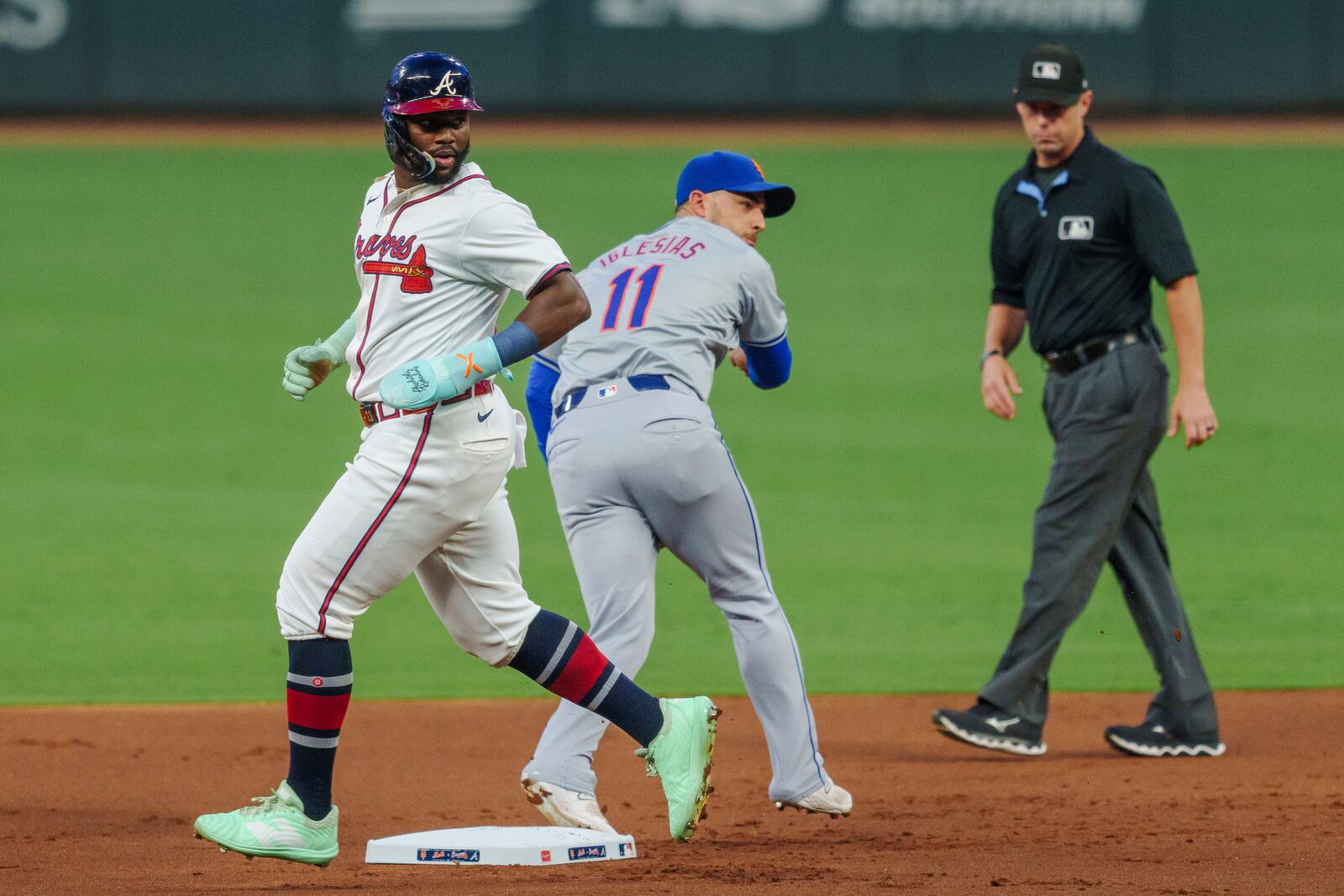 New York Mets second baseman Jose Iglesias, center, tags Atlanta Braves' Michael Harris II, left, out at second base and then attempts to throw out Ozzie Albies (1) at first base in the first inning of a baseball game, Tuesday, Sept. 24, 2024, in Atlanta. (AP Photo/Jason Allen)