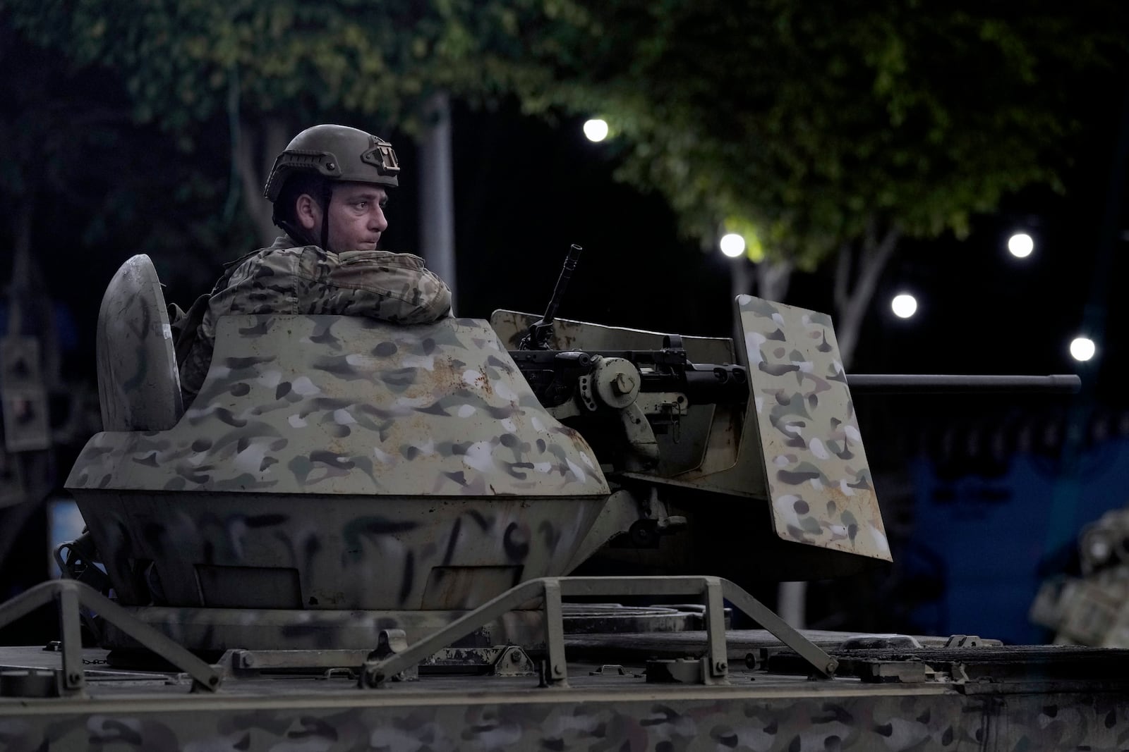 FILE - A Lebanese army soldier sits behind his weapon on the top of an armored personnel carrier at the site of an Israeli airstrike in Beirut's southern suburb, on Sept. 23, 2024. (AP Photo/Bilal Hussein, File)