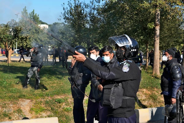 A police officer fires a rubber bullet during clashes with supporters of imprisoned former Premier Imran Khan's Pakistan Tehreek-e-Insaf party, in Islamabad, Pakistan, Tuesday, Nov. 26, 2024. (AP Photo/Anjum Naveed)