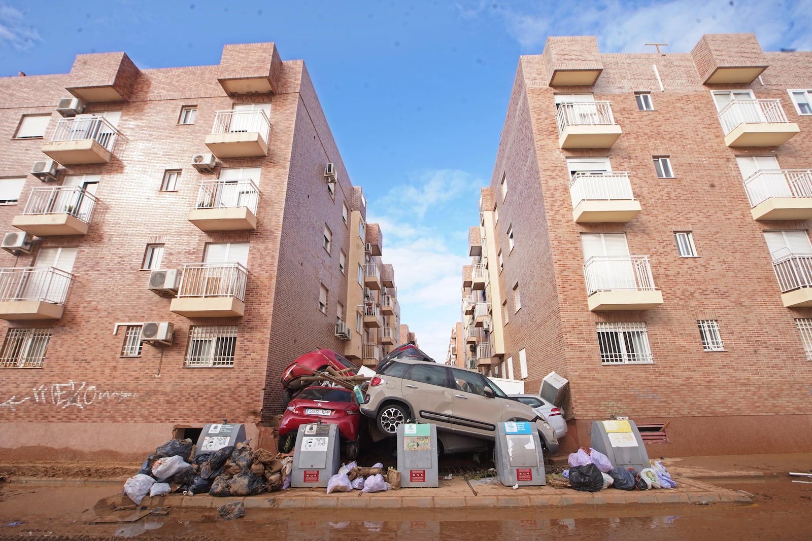 Piled up cars block a street after floods in Massanassa, just outside of Valencia, Spain, Saturday, Nov. 2, 2024. (AP Photo/Alberto Saiz)