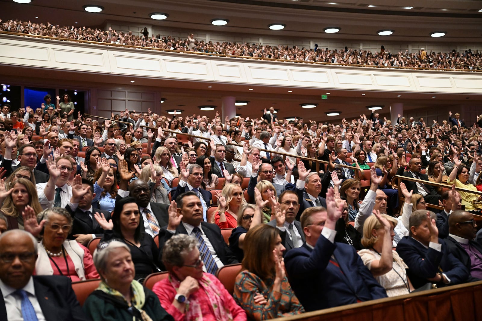 People participate in the sustaining of leadership of the church in the Conference Center in Salt Lake City during the 194th Semiannual General Conference of The Church of Jesus Christ of Latter-day Saints on Saturday, Oct. 5, 2024. (Scott G Winterton/The Deseret News via AP)