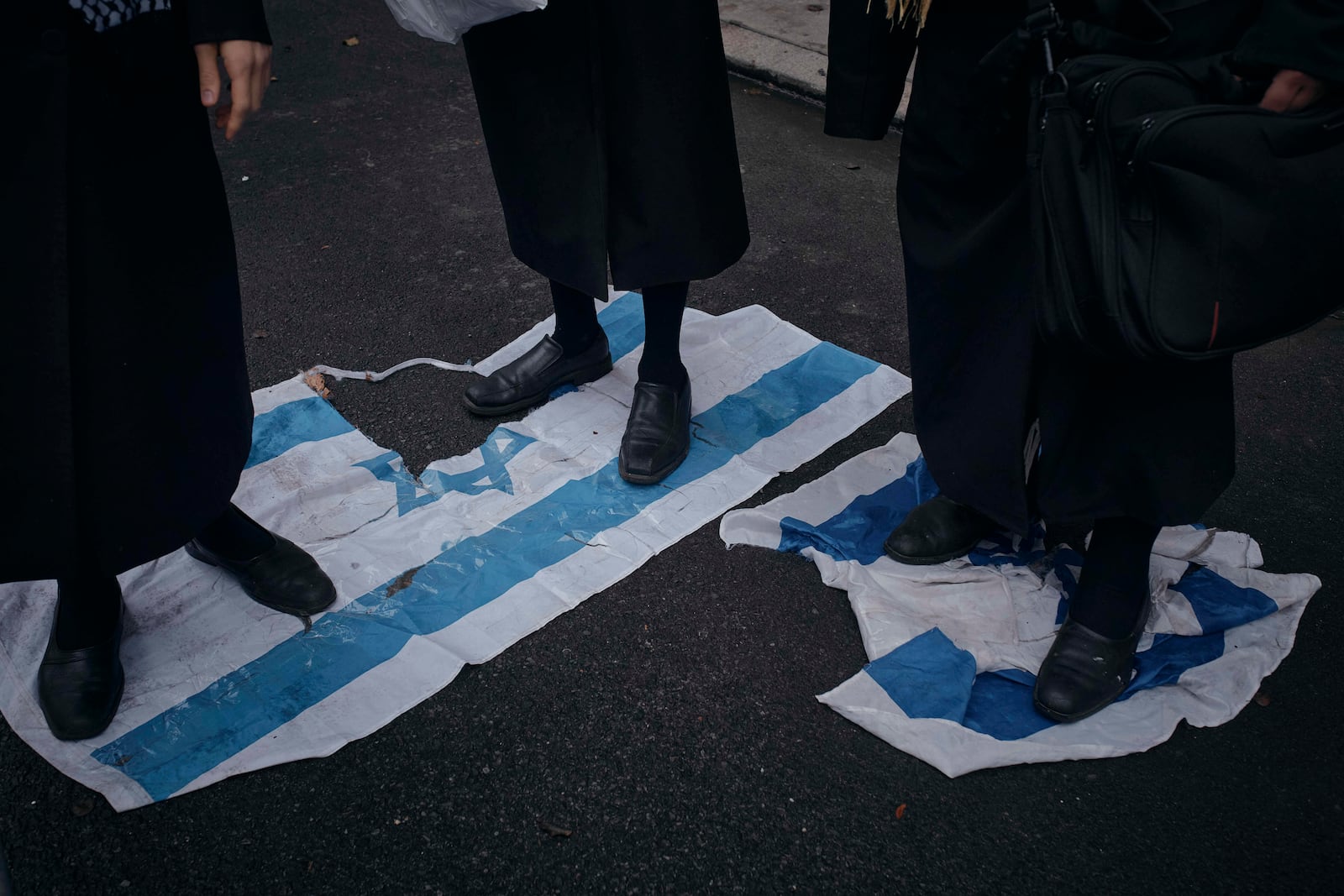 Haredi Jews step on the Israeli flag to protest against Prime Minister of Israel Benjamin Netanyahu in front of his hotel during the 79th session of the United Nations General Assembly, in New York, on Friday, Sept. 27, 2024. (AP Photo/Andres Kudacki)