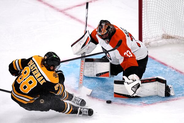 Philadelphia Flyers goaltender Samuel Ersson (33) drops to the ice to make a save on a shot by Boston Bruins right wing David Pastrnak (88) during the first period of an NHL hockey game, Tuesday, Oct. 29, 2024, in Foxborough, Mass. (AP Photo/Charles Krupa)