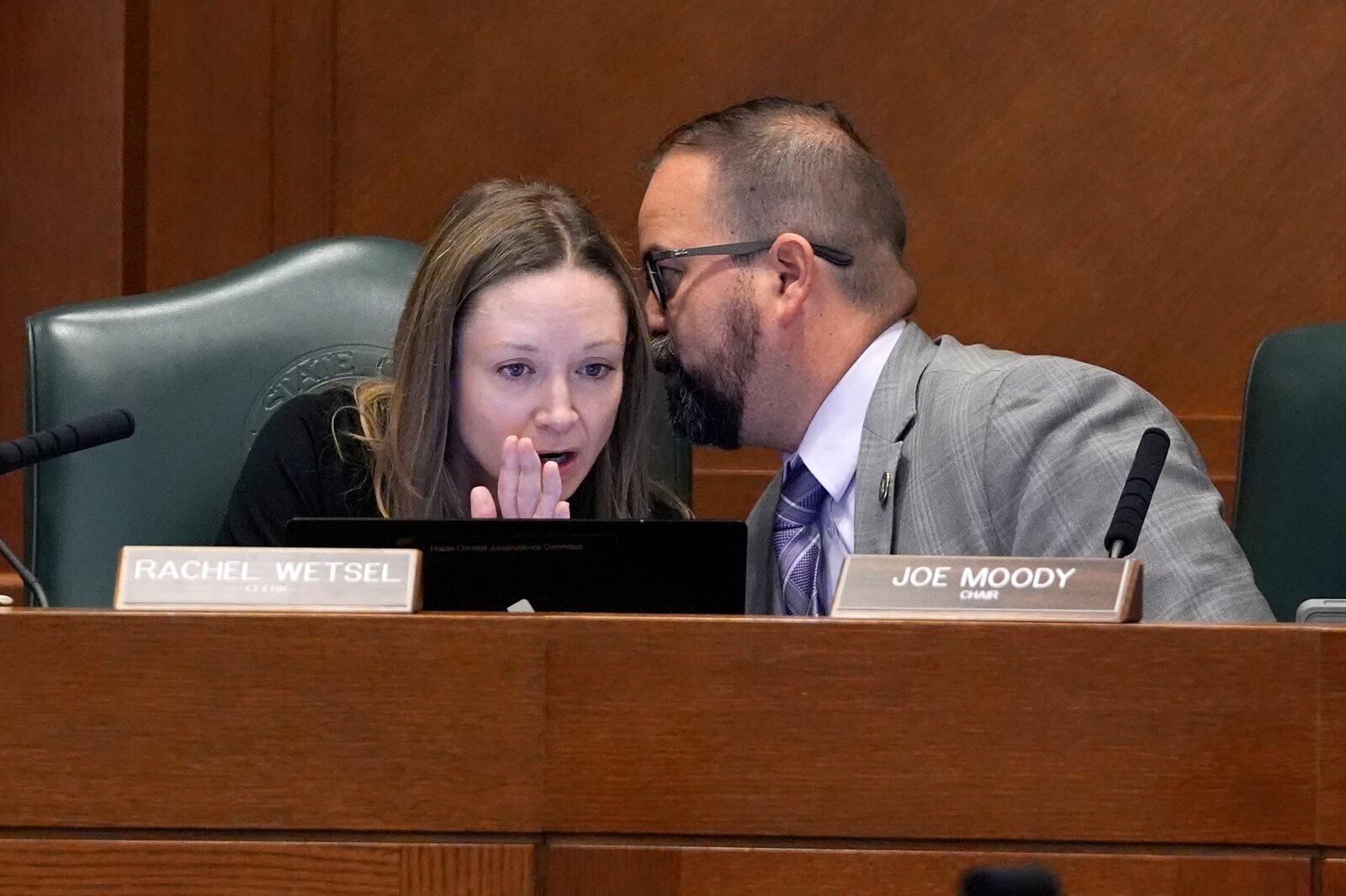 Texas Rep. Joe Moody, D-El Paso, right, talks with Rachel Wetsel, clerk for the state House Committee on Criminal Jurisprudence, left, as a witness gives testimony in the committee hearing regarding the case of death row inmate Robert Roberson, Monday, Oct. 21, 2024, in Austin, Texas. (AP Photo/Tony Gutierrez)