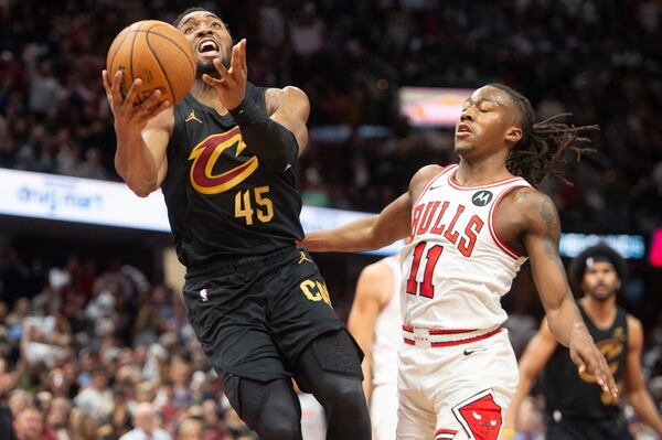 Cleveland Cavaliers' Donovan Mitchell (45) drives to the basket in front of Chicago Bulls' Ayo Dosunmu (11) during the second half of an Emirates NBA Cup basketball game in Cleveland, Friday, Nov. 15, 2024. (AP Photo/Phil Long)