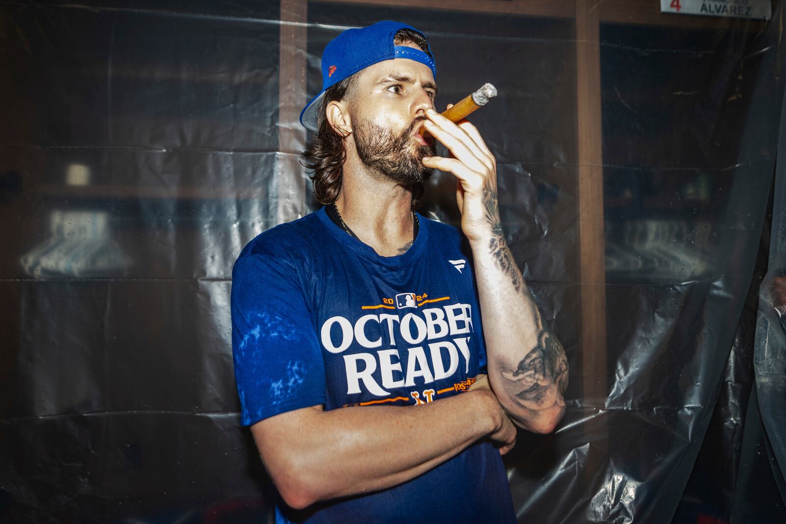 A New York Mets. player smokes a cigar in the locker room after clinching a playoff berth with a victory in the first baseball game of a doubleheader against the Atlanta Braves, Monday, Sept. 30, 2024, in Atlanta. (AP Photo/Jason Allen)