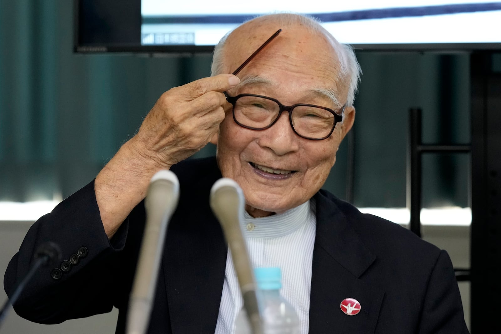 Terumi Tanaka, co-chairperson of Nihon Hidankyo smiles, combing his hair, ahead of a press conference in Tokyo, Saturday, Oct. 12, 2024, a day after Nihon Hidankyo, an organization of survivors of the two U.S. atomic bombings, won the Nobel Peace Prize. (AP Photo/Hiro Komae)