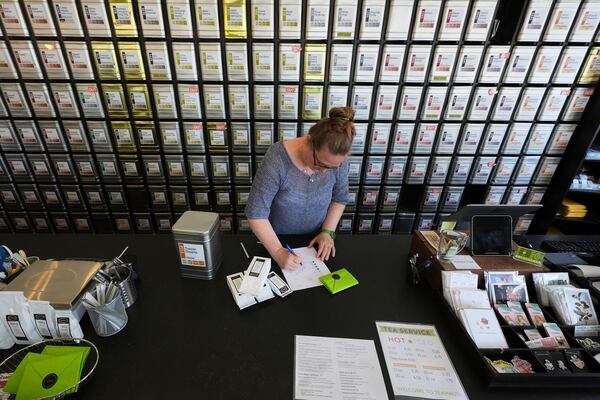 Owner Lisa McDonald packages loose leaf tea orders at the TeaHaus Thursday, April 24, 2025, in Ann Arbor, Mich. (AP Photo/Paul Sancya)
