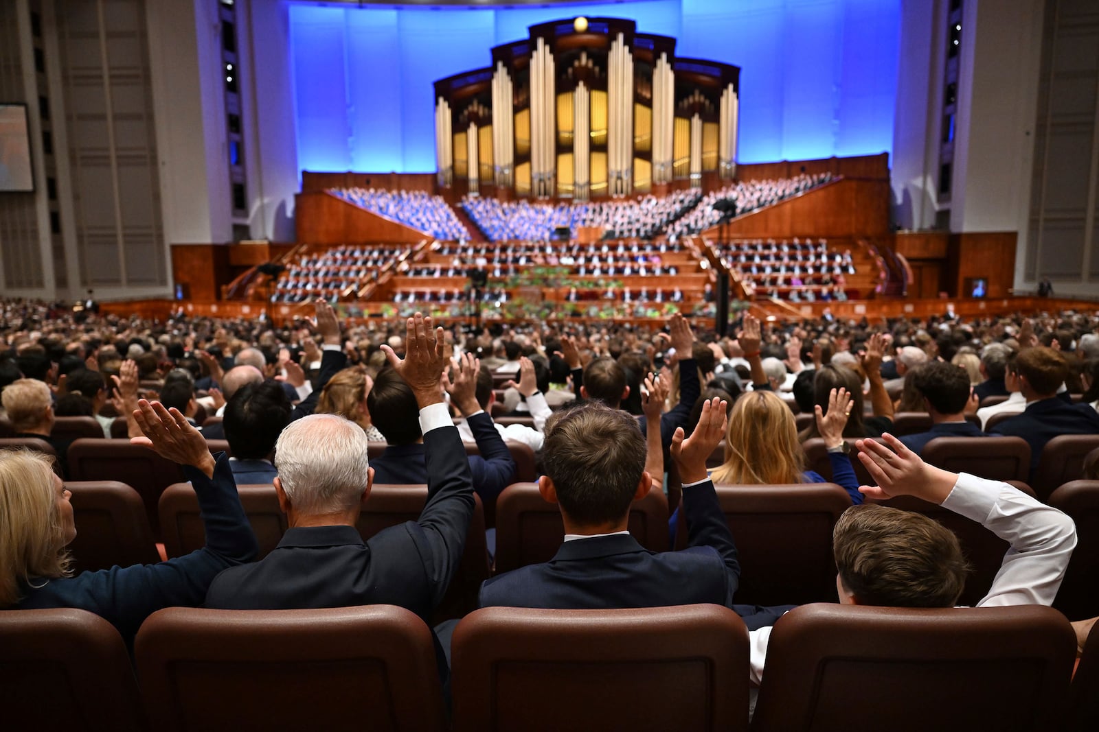 Conferencegoers participate in the sustaining of leadership of the church in the Conference Center in Salt Lake City during the 194th Semiannual General Conference of The Church of Jesus Christ of Latter-day Saints on Saturday, Oct. 5, 2024. (Scott G Winterton/The Deseret News via AP)