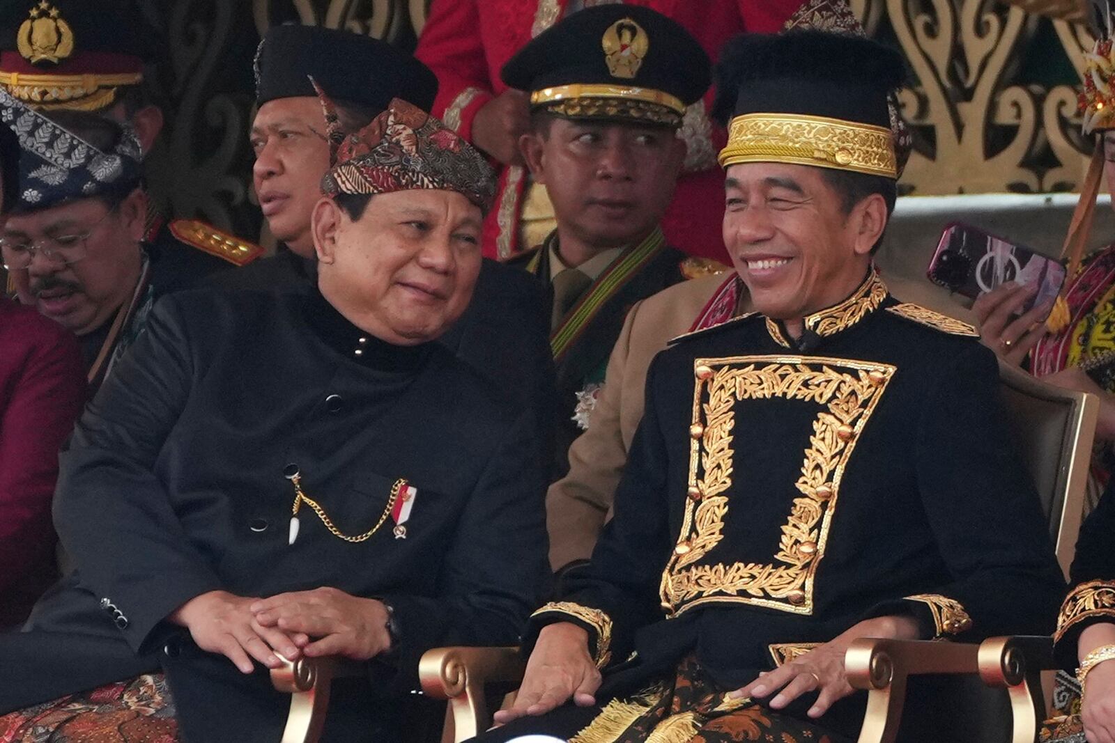 FILE - Defense Minister and president-elect Prabowo Subianto,left, shares a light moment with President Joko Widodo during the ceremony marking Indonesia's 79th anniversary of independence at the new presidential palace in the future capital of Nusantara, a city still under construction on the island of Borneo, Saturday, Aug. 17, 2024. (AP Photo/Achmad Ibrahim, File)