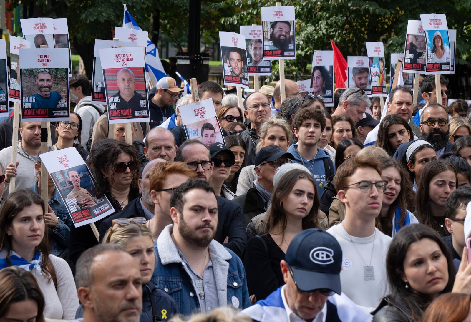 People hold pictures of hostages as they attend a pro-Israel vigil on the anniversary of a Hamas attack on Israel that triggered the ongoing war in Gaza in front of McGill University in Montreal, Canada, Monday, Oct. 7, 2024. (Ryan Remiorz/The Canadian Press via AP)