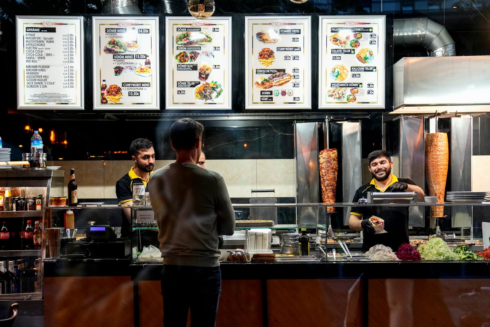 Turkish doner cooks prepare doner kebabs for customers in a doner kebab restaurant in Berlin, Germany, Wednesday, Sept. 18, 2024. (AP Photo/Ebrahim Noroozi)