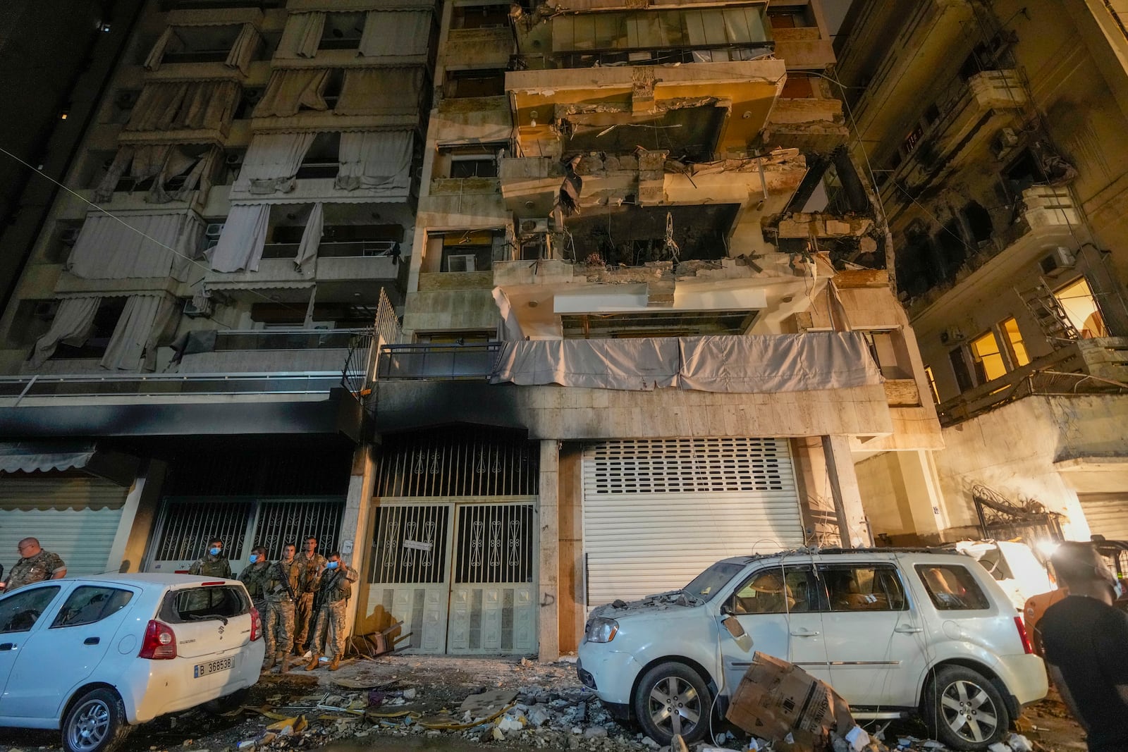 Soldiers stand guard under a building hit by an Israeli airstrike in Beirut, Lebanon, Thursday, Oct. 10, 2024. (AP Photo/Hassan Ammar)