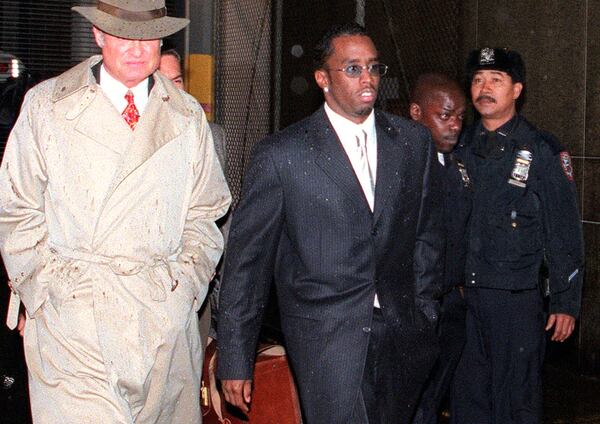 FILE - Rap artist and music producer Sean "Puffy" Combs, center, leaves a court hearing at New York's Manhattan Criminal Court on April 16, 1999, after Combs was charged with beating rap record executive, Steven Stoute, the previous day. (AP Photo/Robert Mecea, File)