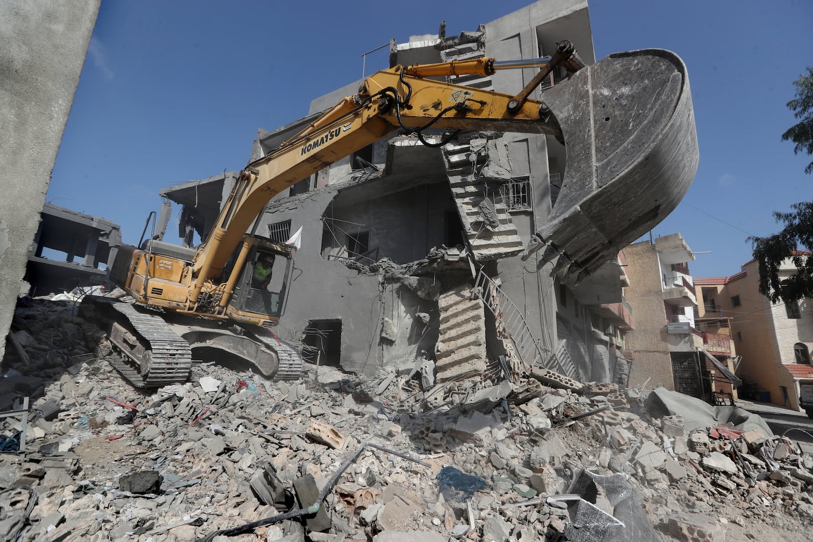 An excavator is used by a rescue worker to remove the rubble of destroyed buildings at the site that was hit by Israeli airstrikes in Qana village, south Lebanon, Wednesday, Oct. 16, 2024. (AP Photo/Mohammed Zaatari)