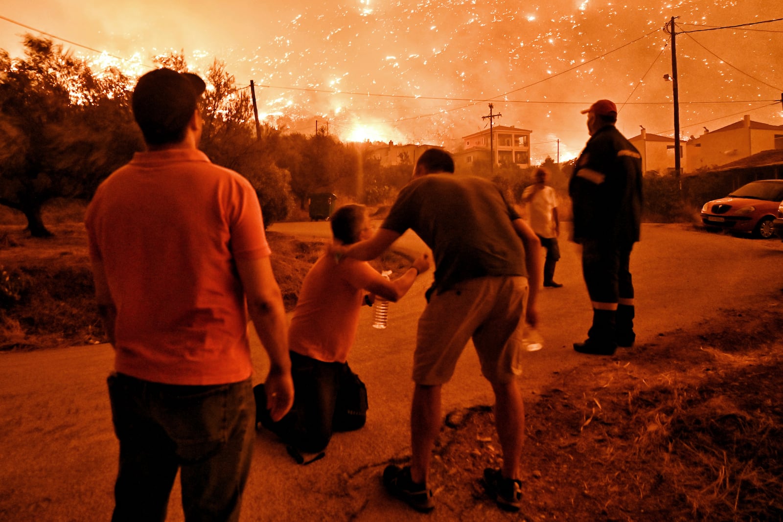 A resident reacts as a wildfire approaches the village of Ano Loutro as fanned by strong winds raged uncontrolled despite the attempts of hundreds of firefighters to stop it, some 131 kilometers (81 miles) west of Athens, Greece, in the region of Corinthia, late Sunday, Sept. 29, 2024. (AP Photo)