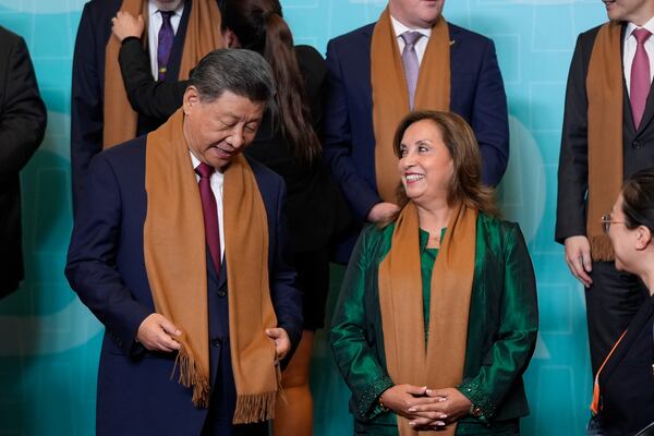 China's President Xi Jinping, left, speaks with Peru's President Dina Boluarte, right, as they and other APEC leaders gather for a family photograph at the APEC Summit in Lima, Peru on Saturday, Nov. 16, 2024. (AP Photo/Manuel Balce Ceneta)