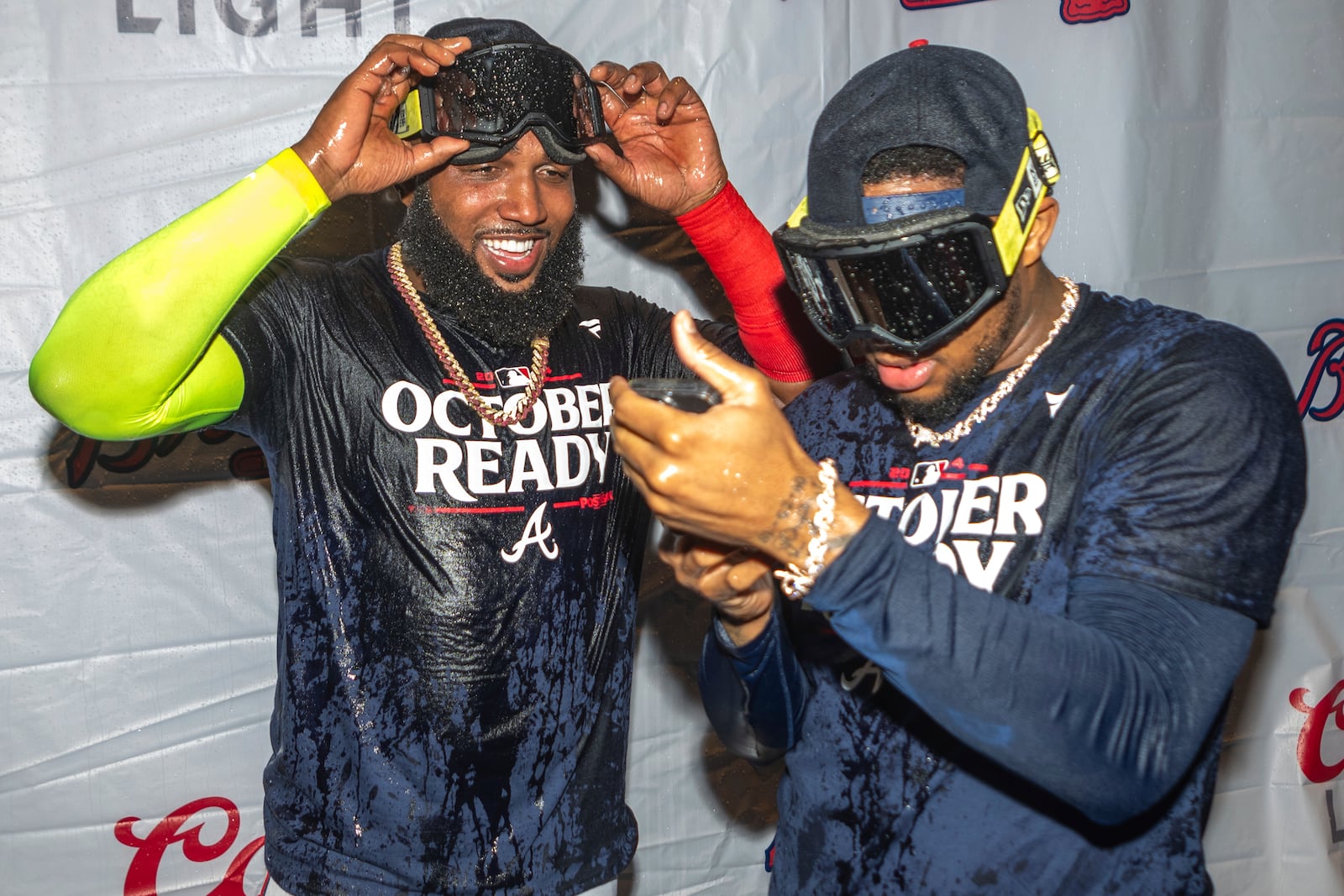 Atlanta Braves designated hitter Marcell Ozuna, left, celebrates with outfielder Ronald Acuña Jr., right, in the locker room after clinching a wild-card playoff berth after the second baseball game of a doubleheader against the New York Mets, Monday, Sept. 30, 2024, in Atlanta. (AP Photo/Jason Allen)