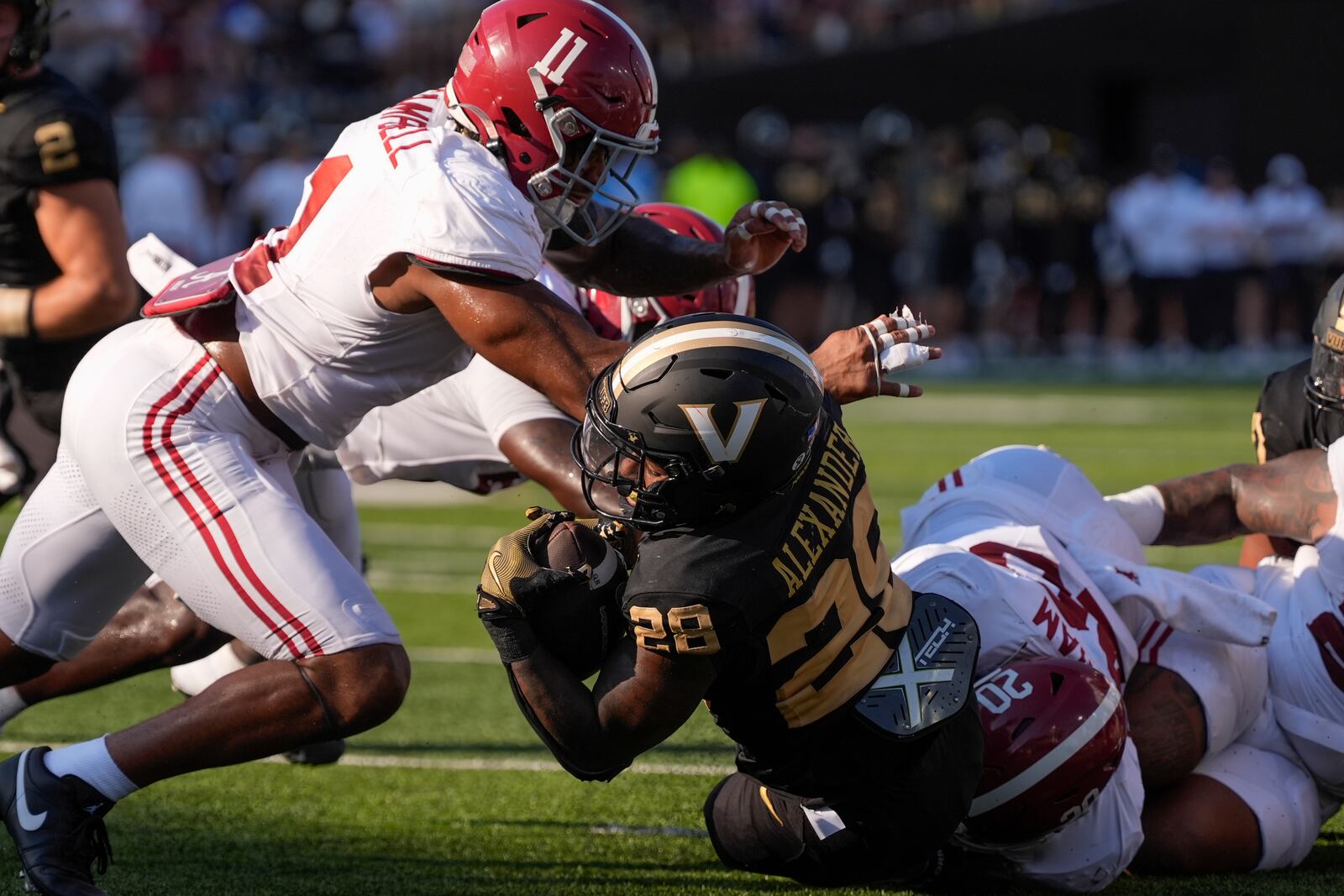 Vanderbilt running back Sedrick Alexander (28) is stopped short to the end zone by Alabama linebacker Jihaad Campbell (11) and defensive lineman Jah-Marien Latham (20) during the first half of an NCAA college football game Saturday, Oct. 5, 2024, in Nashville, Tenn. (AP Photo/George Walker IV)