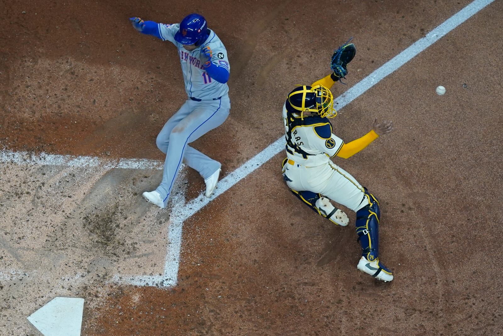 New York Mets' Jose Iglesias scores past Milwaukee Brewers catcher William Contreras during the fifth inning of Game 2 of a National League wild card baseball game Tuesday, Oct. 1, 2024, in Milwaukee. (AP Photo/Morry Gash)