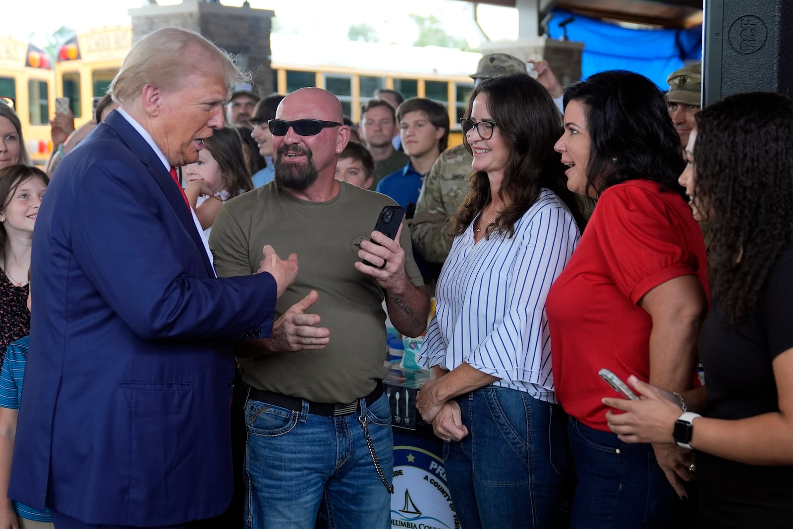 Republican presidential nominee former President Donald Trump greets people at a temporary relief shelter as he visits areas impacted by Hurricane Helene, Friday, Oct. 4, 2024, in Evans, Ga. (AP Photo/Evan Vucci)