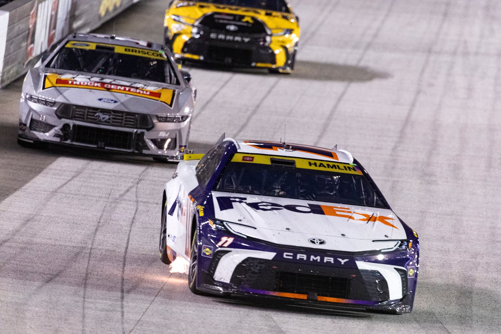 Denny Hamlin (11) leads Chase Briscoe (14) and Christopher Bell (20) during a NASCAR Cup Series auto race, Saturday, Sept. 21, 2024, in Bristol, Tenn. (AP Photo/Wade Payne)