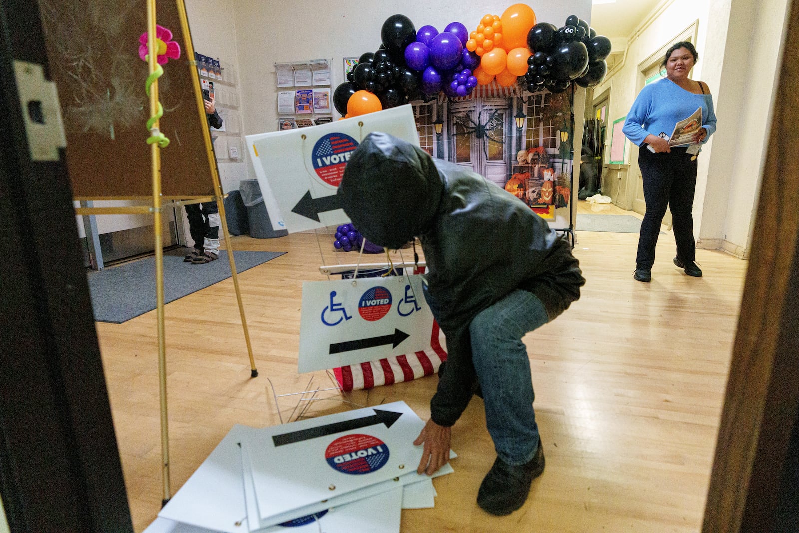 Election workers take down election signs as they close off the voting and drop off site at the Echo Park Recreation Center on Tuesday, Nov. 5, 2024, in Los Angeles. (AP Photo/Damian Dovarganes)