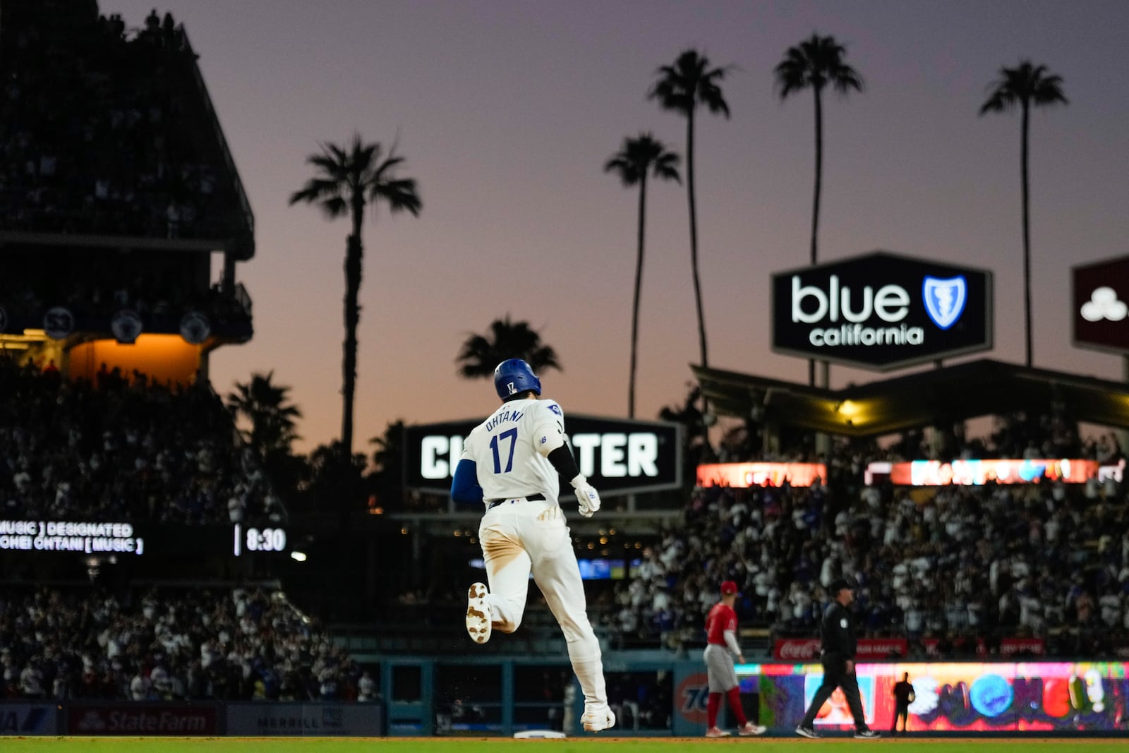 Los Angeles Dodgers designated hitter Shohei Ohtani (17) runs the bases after hitting a home run during the fifth inning of a baseball game against the Los Angeles Angels in Los Angeles, Friday, June 21, 2024. Austin Barnes also scored. (AP Photo/Ashley Landis)