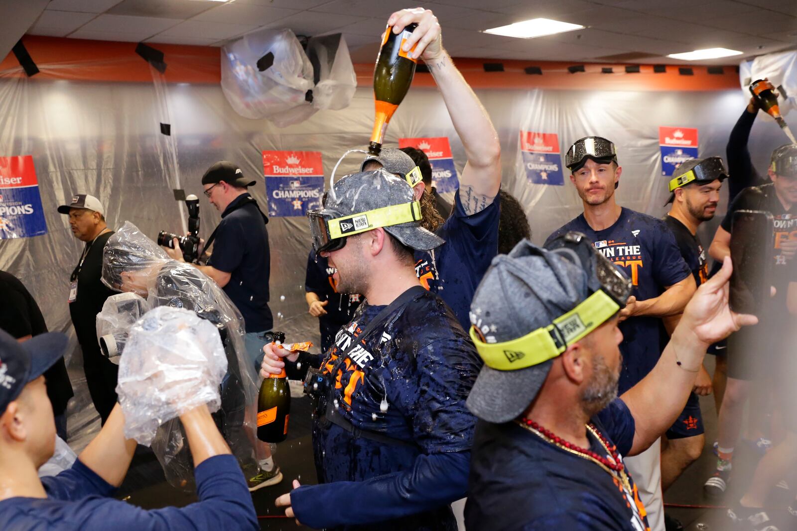 Houston Astros' Chas McCormick, center, is doused with champagne as the team celebrates in the clubhouse after defeating the Seattle Mariners 4-3 to clinch the AL West title after a baseball game Tuesday, Sept. 24, 2024, in Houston. (AP Photo/Michael Wyke)