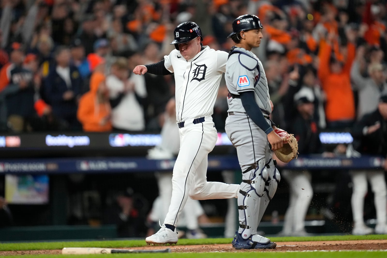 Detroit Tigers' Kerry Carpenter, left, scores in front of Cleveland Guardians catcher Bo Naylor in the sixth inning during Game 4 of a baseball American League Division Series, Thursday, Oct. 10, 2024, in Detroit. (AP Photo/Paul Sancya)