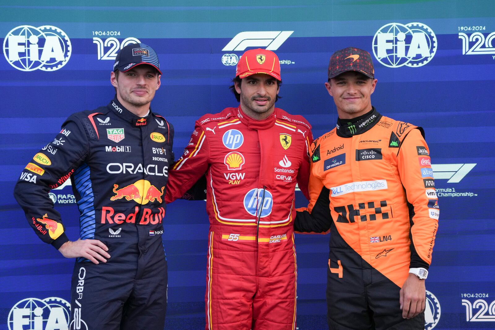 Ferrari driver Carlos Sainz, center, of Spain, poses for photos with Red Bull driver Max Verstappen, left, of the Netherlands, second place, and McLaren driver Lando Norris, of Britain, after winning the pole position a day ahead of the Formula One Mexico Grand Prix auto race at the Hermanos Rodriguez racetrack in Mexico City, Saturday, Oct. 26, 2024. (AP Photo/Fernando Llano)