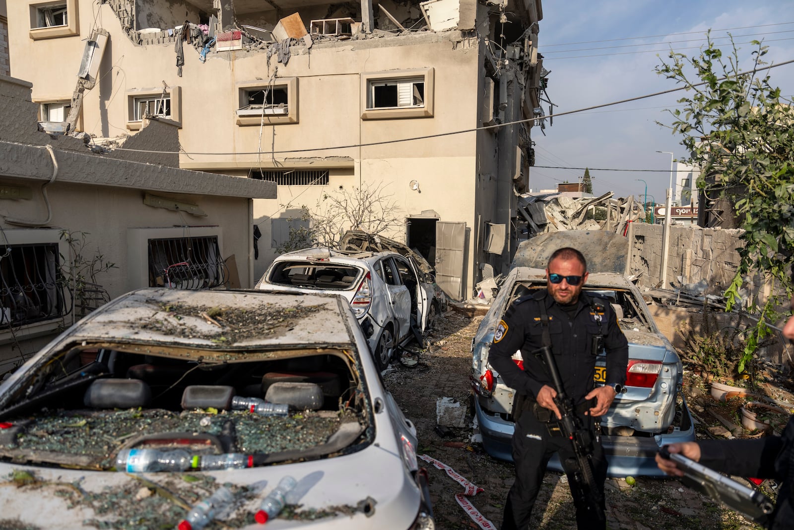 Israeli police men work at the site where projectiles fired from Lebanon hit a home in Tira, central Israel, Saturday, Nov. 2, 2024. (AP Photo/Ariel Schalit)