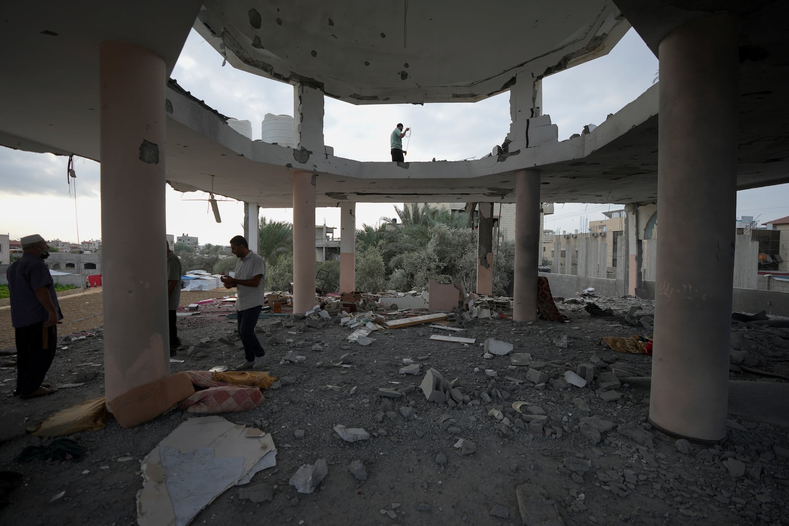 Palestinians examine a destroyed mosque following an Israeli airstrike in Deir al-Balah, Sunday, Oct. 6, 2024. (AP Photo/Abdel Kareem Hana)