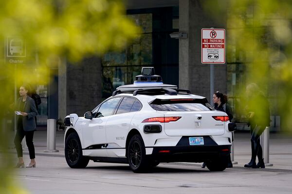 FILE - A Waymo self-driving vehicle sits curbside on Dec. 16, 2022, at the Sky Harbor International Airport Sky Train facility in Phoenix. (AP Photo/Matt York, File)