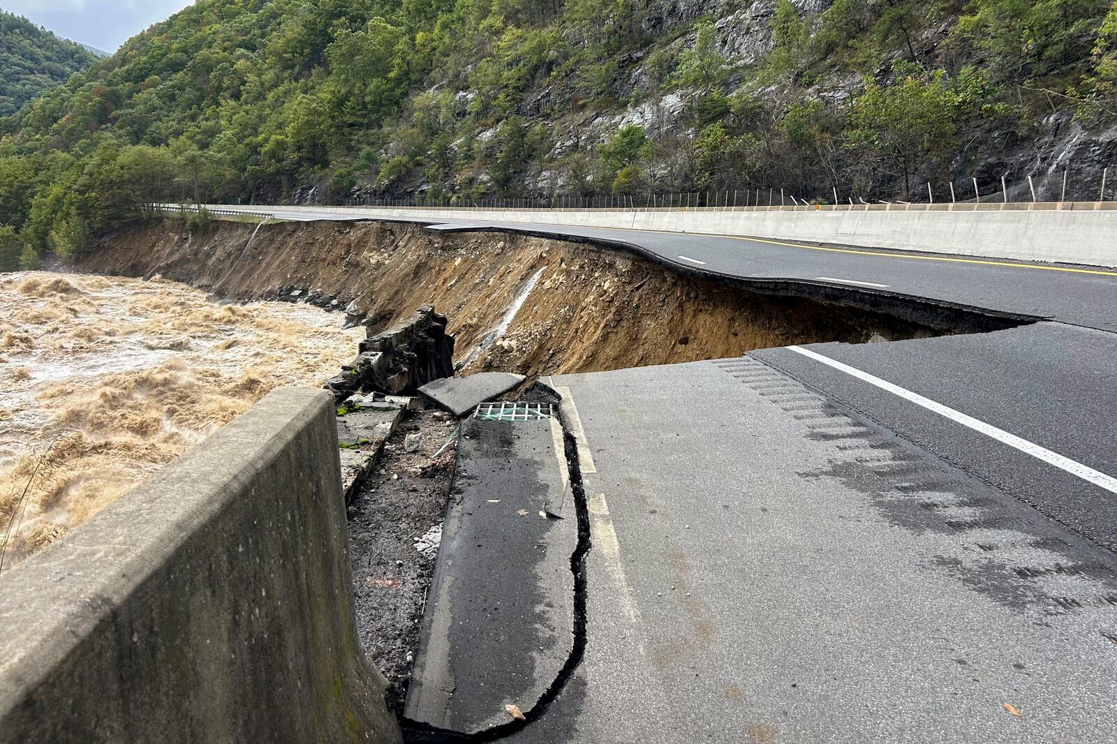 This photo provided by the North Carolina Department of Transportation shows the collapsed eastbound lane of I-40 into the Pigeon River in North Carolina near the Tennessee border on Saturday, Sept. 28, 2024. (N.C. Department of Transportation via AP)