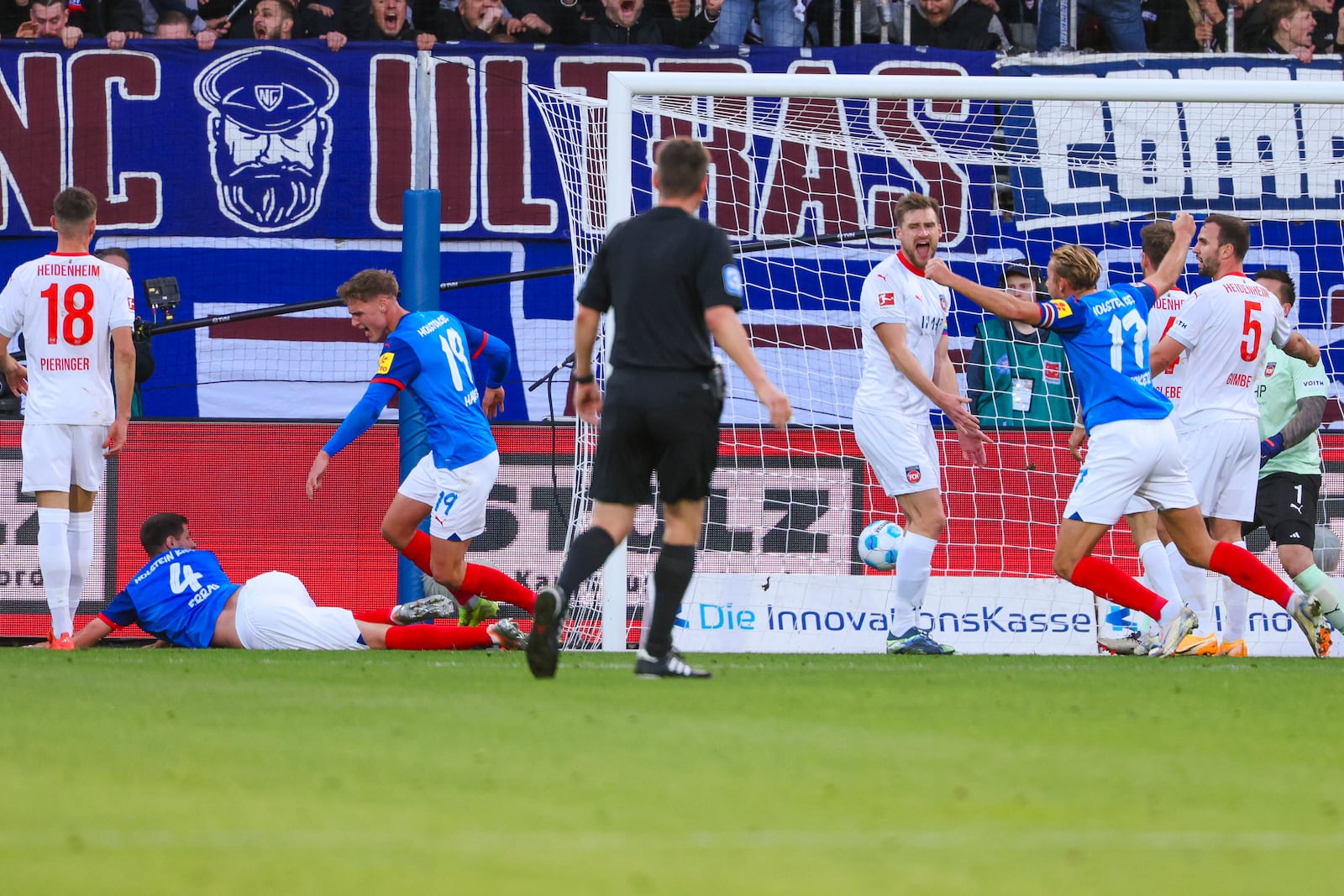 Kiel's Patrick Erras, left, scores his team's first goal during the Bundesliga soccer match between Holstein Kiel and FC Heidenheim at the Holstein Stadium in Kiel, Germany, Saturday, Nov. 2, 2024. (Frank Molter/dpa via AP)