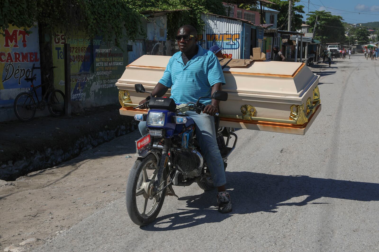 A motorist carries an empty coffin to a morgue for the funeral of a person killed the previous week when a gang attacked the town of Pont-Sonde, Haiti, Monday, Oct. 7, 2024. (AP Photo/Odelyn Joseph)