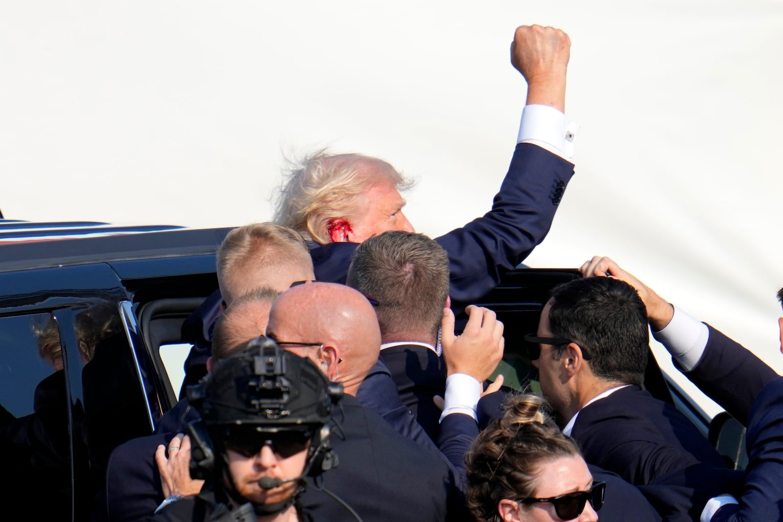 FILE - Republican presidential candidate former President Donald Trump pumps his fist as he is escorted into a vehicle at a campaign event in Butler, Pa., July 13, 2024. (AP Photo/Gene J. Puskar, File)