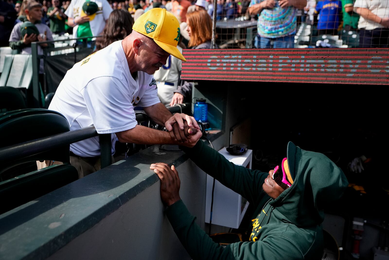 Fan Michael Marler, also known as "Road Trip Mike," greets Oakland Athletics right fielder Lawrence Butler before a baseball game against the Seattle Mariners, Sunday, Sept. 29, 2024, in Seattle. (AP Photo/Lindsey Wasson)