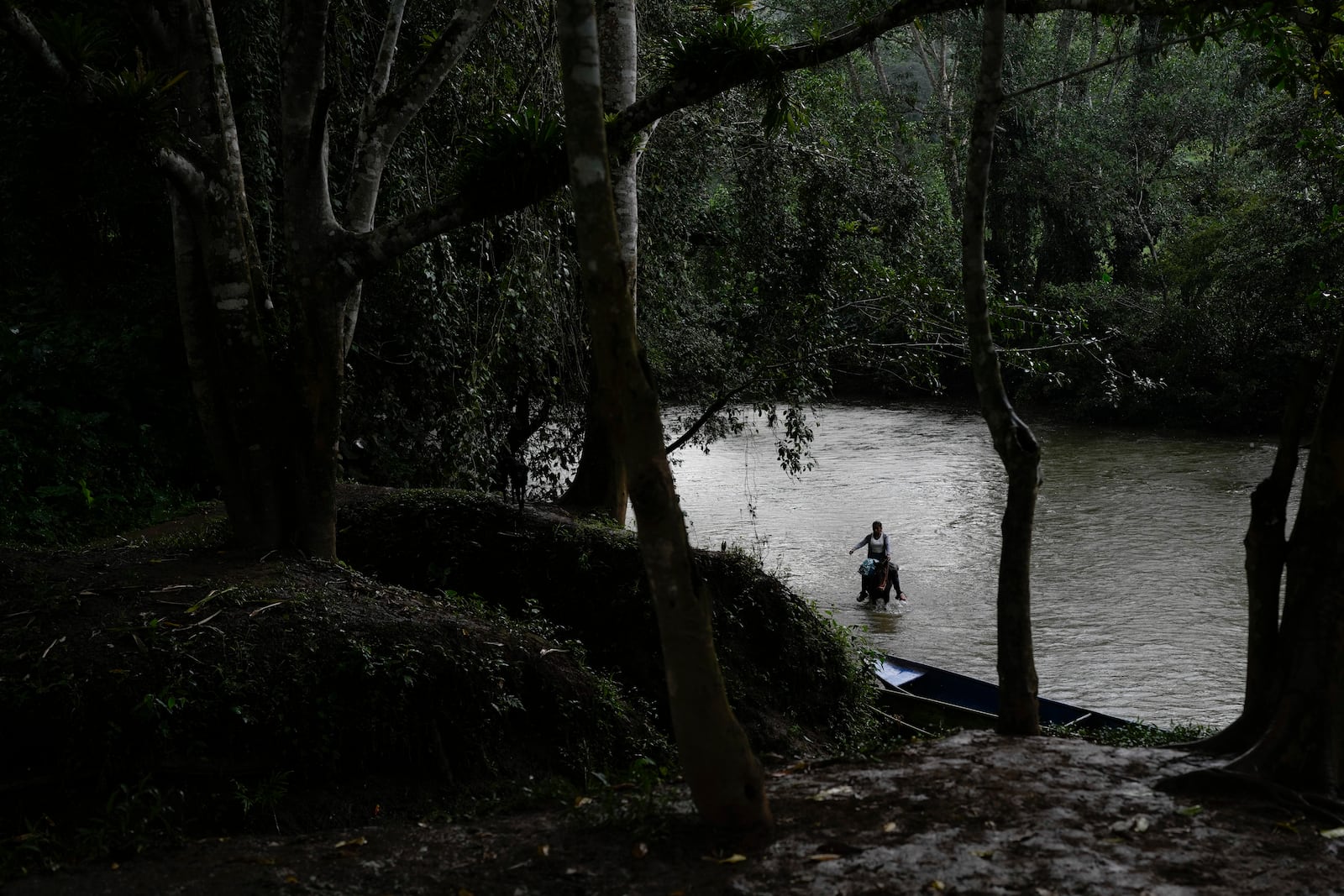 A woman rides her horse in the Indio River, which could have its flow reduced and submerge her community of Limon under a proposed plan to secure the Panama Canal’s uninterrupted operation, in Panama, Saturday, Aug. 31, 2024. (AP Photo/Matias Delacroix)