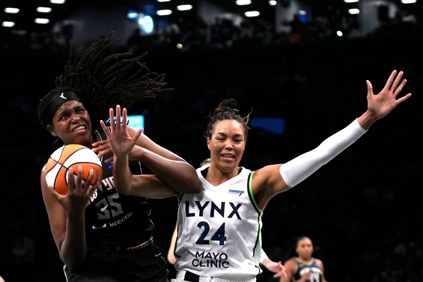 New York Liberty's Jonquel Jones, left, attempts to score against Minnesota Lynx's Napheesa Collier (24) during the first half in Game 1 of a WNBA basketball final playoff series, Thursday, Oct. 10, 2024, in New York. (AP Photo/Pamela Smith)