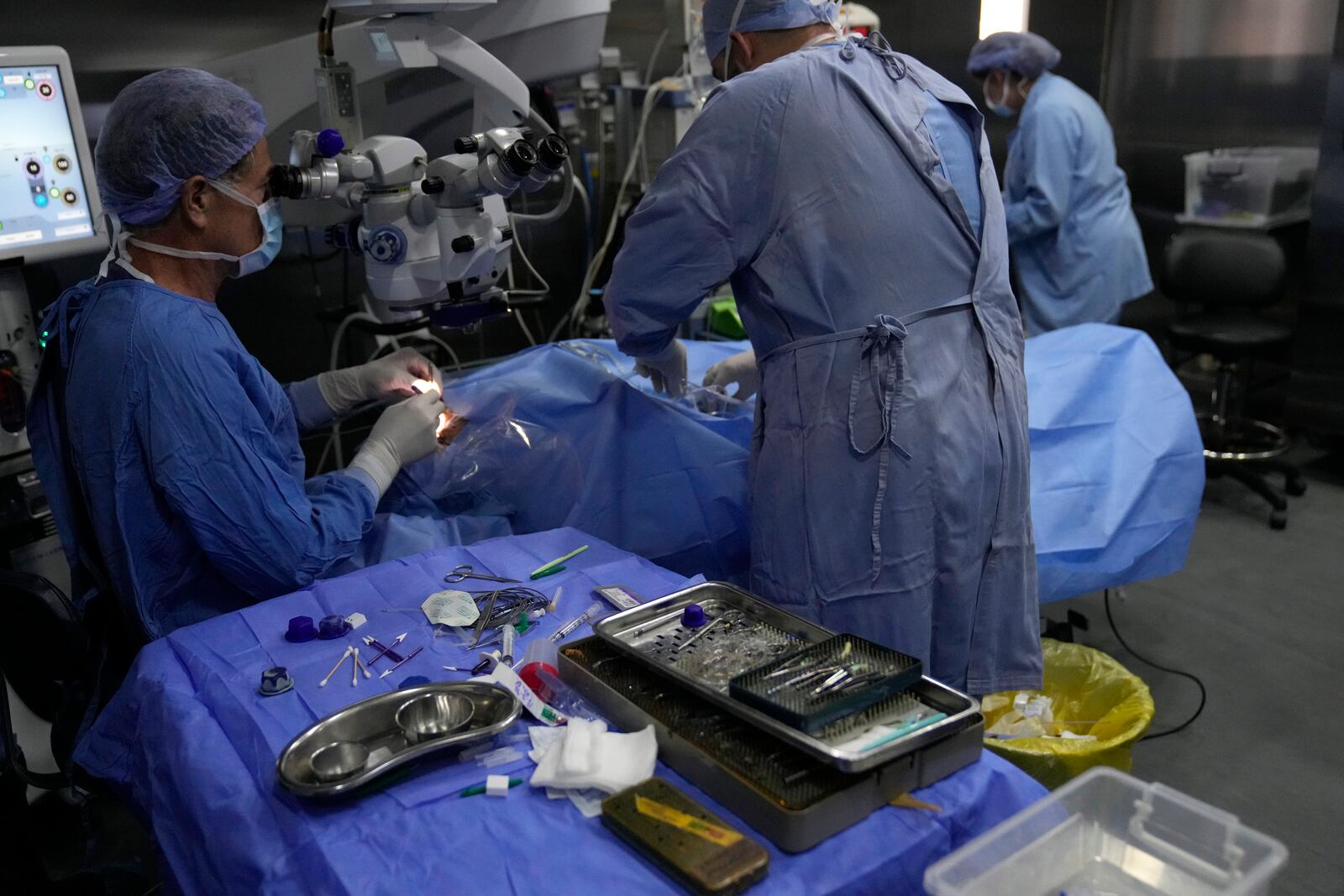 Elias Jaradeh, a legislator and an ophthalmologist, left, who has conducted dozens of operation for victims of this week's attack in Lebanon, makes an eye surgery operation for a man who was injured in the explosion of one of the handheld devices, at the Eye Specialist hospital, in Beirut, Lebanon, Friday, Sept. 20, 2024. (AP Photo/Hussein Malla)