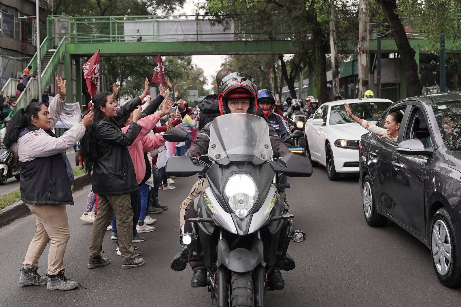 Claudia Sheinbaum waves to supporters from the vehicle taking her to Congress to assume the presidency in Mexico City, Tuesday, Oct. 1, 2024. (AP Photo/Aurea Del Rosario)