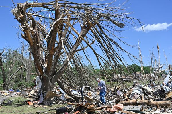 Dennis Clark goes through the remains of his house that was destroyed by severe weather in London, Ky., Saturday, May 17, 2025. (AP Photo/Timothy D. Easley)