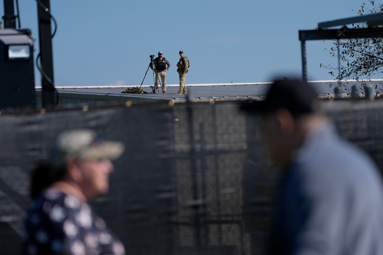 Members of law enforcement stands on a roof before Republican presidential nominee former President Donald Trump speaks at a campaign rally at the Butler Farm Show, the site where a gunman tried to assassinate him in July, Saturday, Oct. 5, 2024, in Butler, Pa. (AP Photo/Alex Brandon)