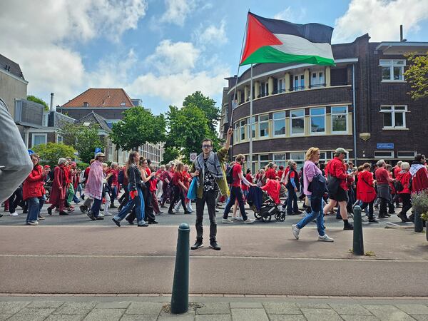 A demonstrator holds a Palestinian flag during the Red Line protest in The Hague, Netherlands on Sunday, May 18, 2025. (Niels van der Pas via AP)