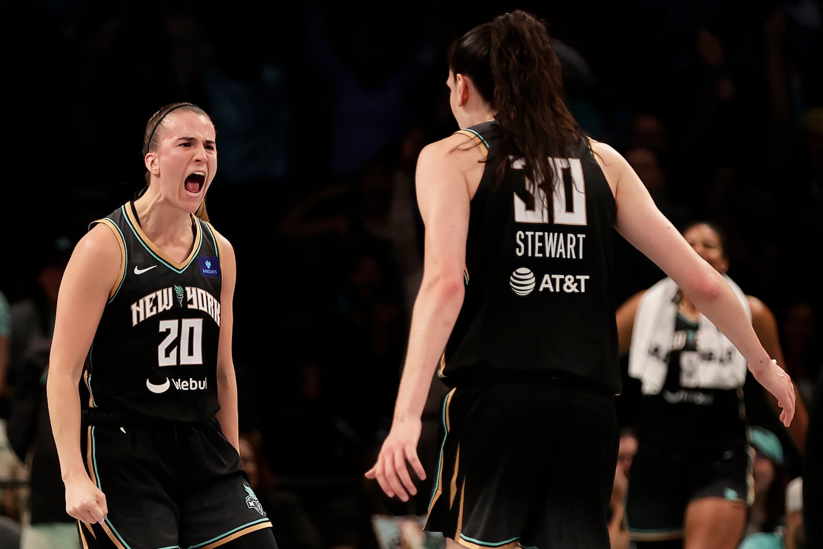 New York Liberty guard Sabrina Ionescu (20) reacts with Breanna Stewart (30) during the first half of a first-round WNBA basketball playoff game against the Atlanta Dream, Tuesday, Sept. 24, 2024, in New York. (AP Photo/Adam Hunger)