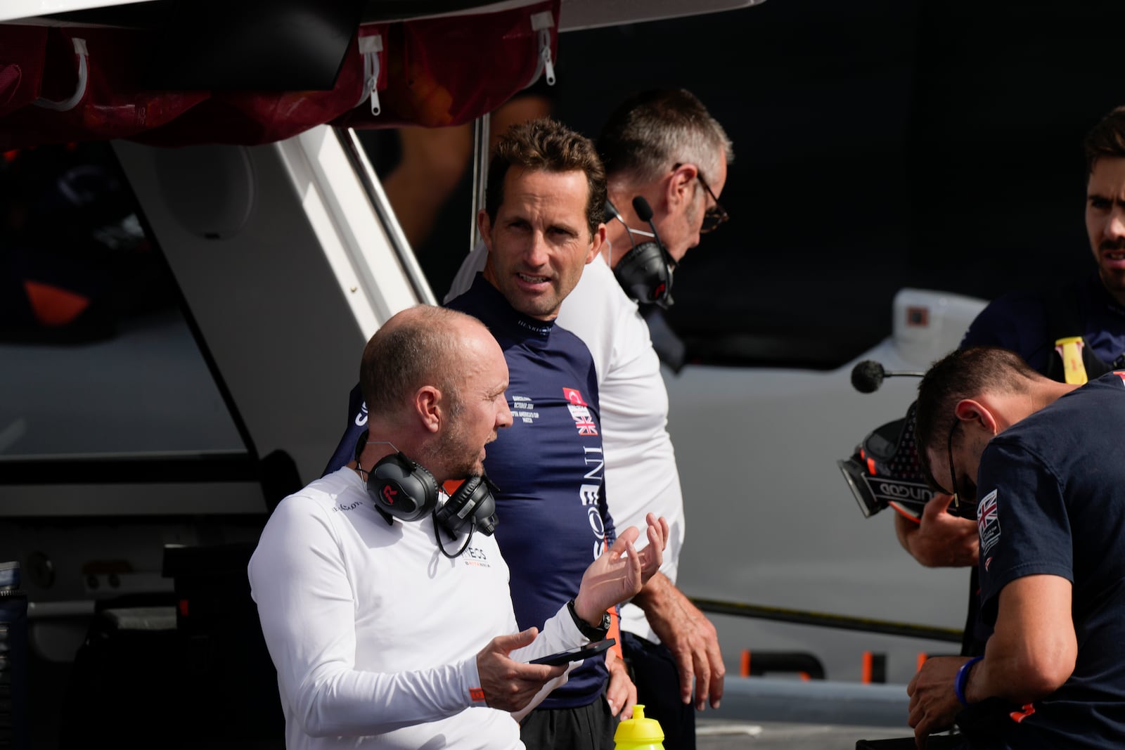 Ineos Britannia skipper Ben Ainslie, center, talks to the crew during the Louis Vuitton 37th America's Cup Day 2 race in Barcelona, Spain, Sunday, Oct. 13, 2024. (AP Photo/Bernat Armangue)